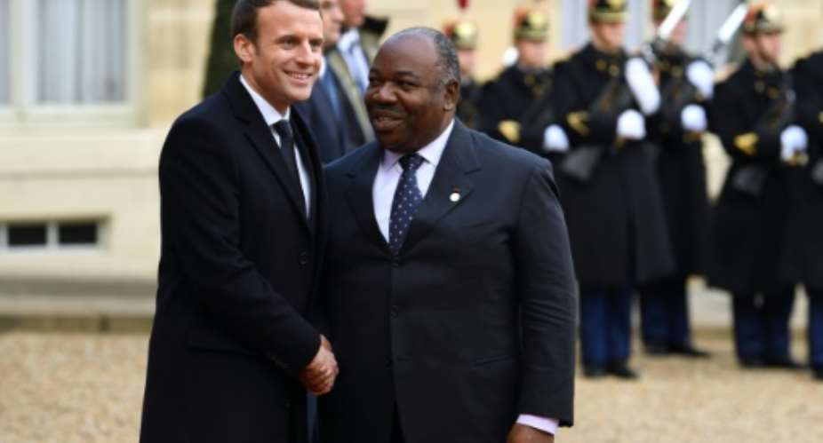 French President Emmanuel Macron greets Gabon President  Ali Bongo Ondimba as he arrives at the Elysee palace in Paris in 2017.  By ALAIN JOCARD AFP