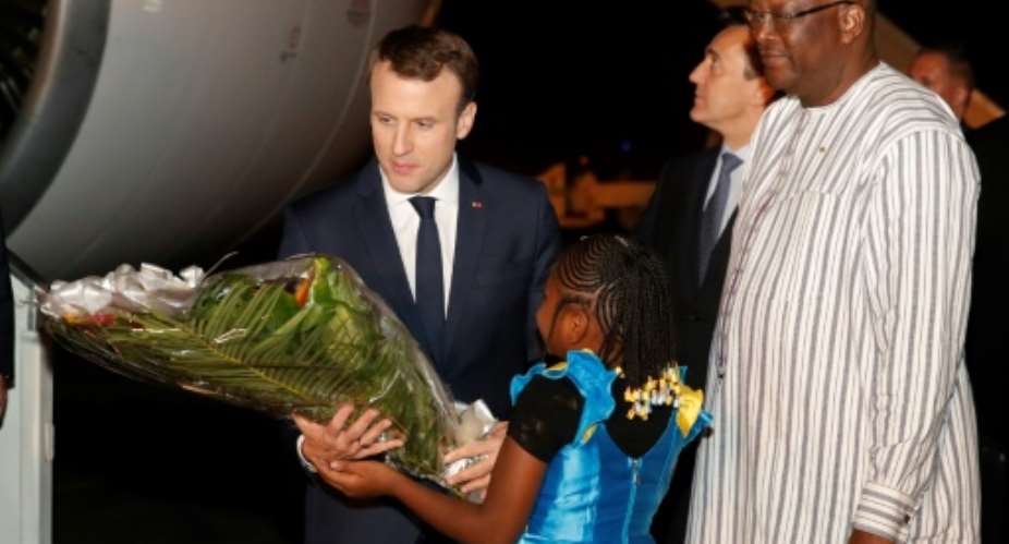 French President Emmanuel Macron L is welcomed by Burkina Faso's President Roch Marc Christian Kabore R at Ouagadougou airport.  By PHILIPPE WOJAZER POOLAFP