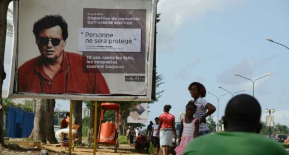 French-Canadian journalist Guy-Andre Kieffer pictured on the billboard was last seen in a car park in Abidjan in April 2004 with Michel Legre.  By Issouf Sanogo AFPFile