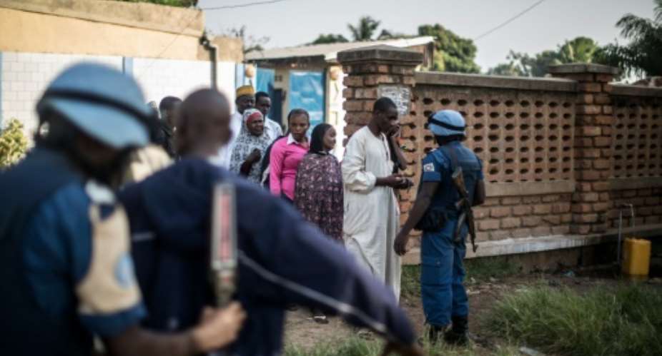 A soldier of the UN peacekeeping force MINUSCA contingent uses a metal detector at the entrance of a polling station in the flashpoint PK5 district in Bangui on December 14, 2015.  By Marco Longari AFPFile