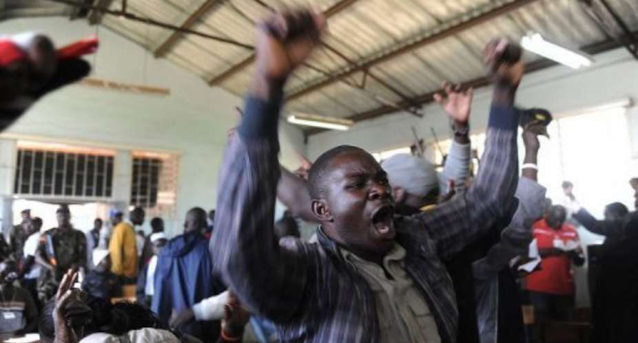 A voter celebrates a win for his candidate on March 6, 2013 at a polling station in Nairobi's Mathare slum.  By Simon Maina AFP