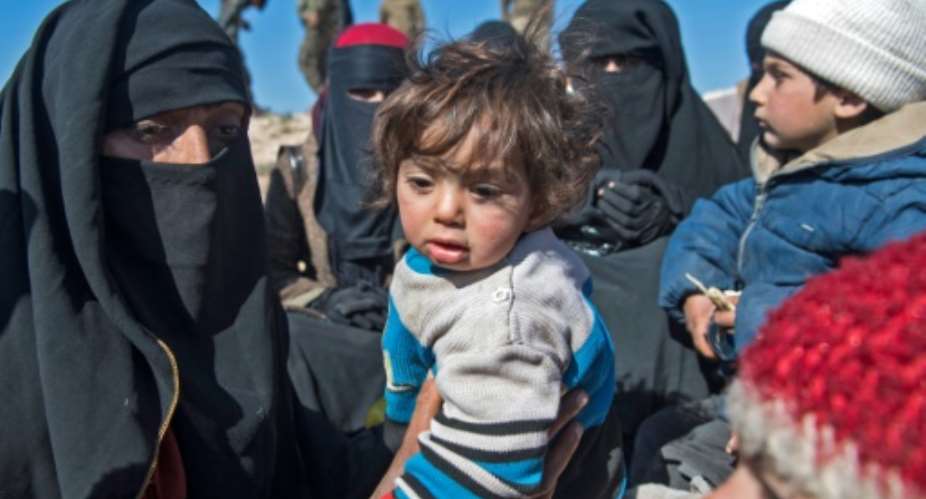 Fully veiled women and children gather after fleeing from the Baghouz area in the eastern Syrian province of Deir Ezzor on February 12, 2019 during an operation by the US-backed Syrian Democratic Forces (SDF) against the Islamic State group.  By Fadel SENNA (AFP)