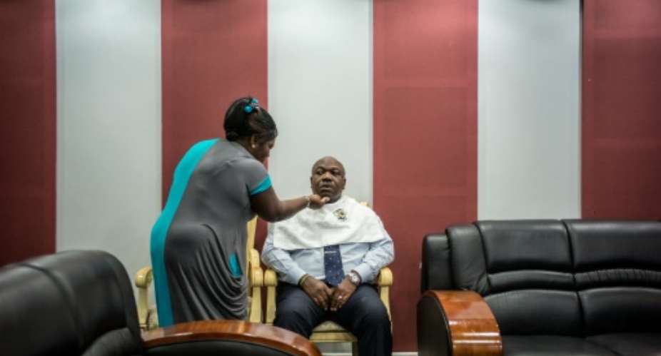 Gabon President Ali Bongo sits for make up ahead of a televised electoral debate in Libreville.  By Marco Longari AFP