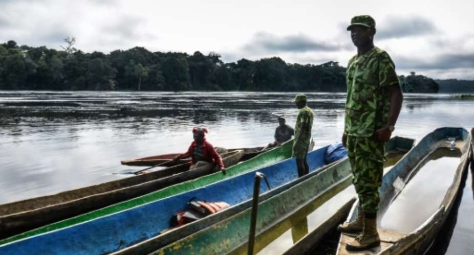Rangers stop pirogues to check for arms and ammunition, on a stretch of the Ivindo river in the Ivindo National Park, Gabon.  By Celia Lebur AFP