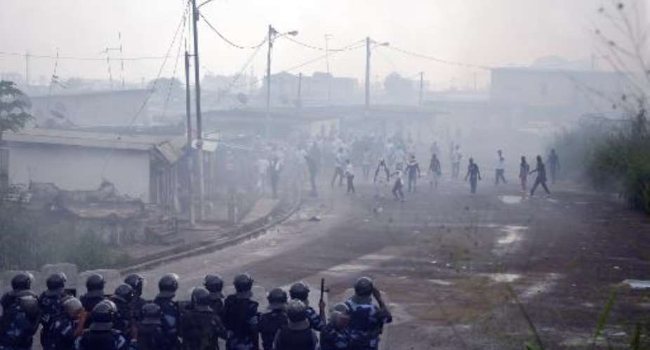 Protesters clash with police in the Rio district of Libreville on December 20, 2014.  By Celia Lebur AFP
