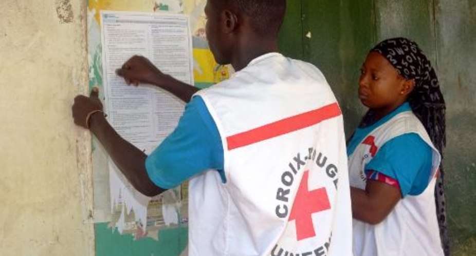 Members of the Guinean Red Cross post information concerning the Ebola virus during an awareness campaign on April 11, 2014 in Conakry.  By Cellou Binani AFPFile