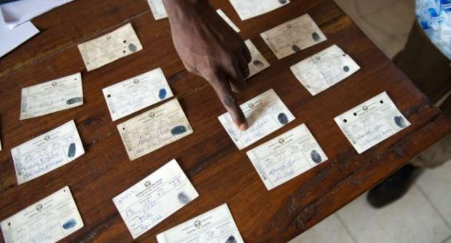 A member of the Party for Social Renewal PRS shows allegedly fraudulent voter cards.  By Phil Moore AFPFile