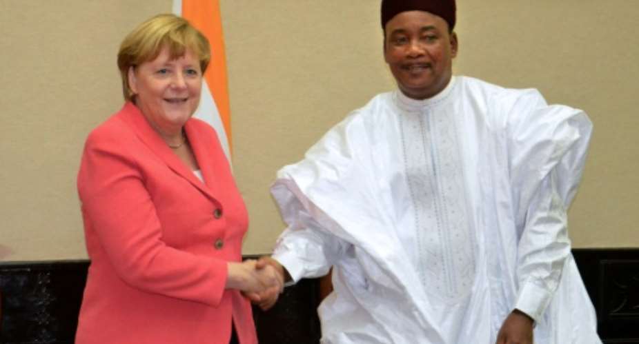 German Chancellor Angela Merkel L meets with Mahamadou Issoufou of Niger at the presidential palace in Niamey on October 10, 2016.  By Boureima Hama AFP