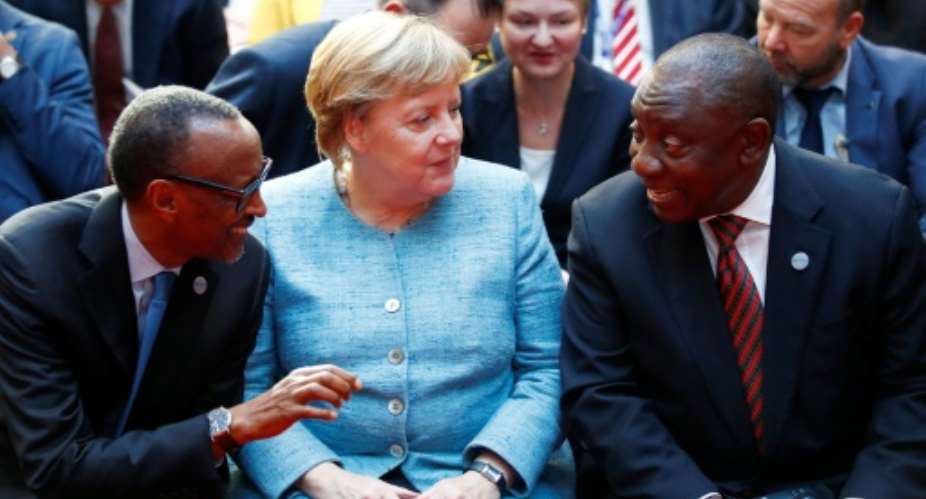 German Chancellor Angela Merkel with Rwanda President Paul Kagame left and South African President Cyril Ramaphosa right.  By AXEL SCHMIDT POOLAFP