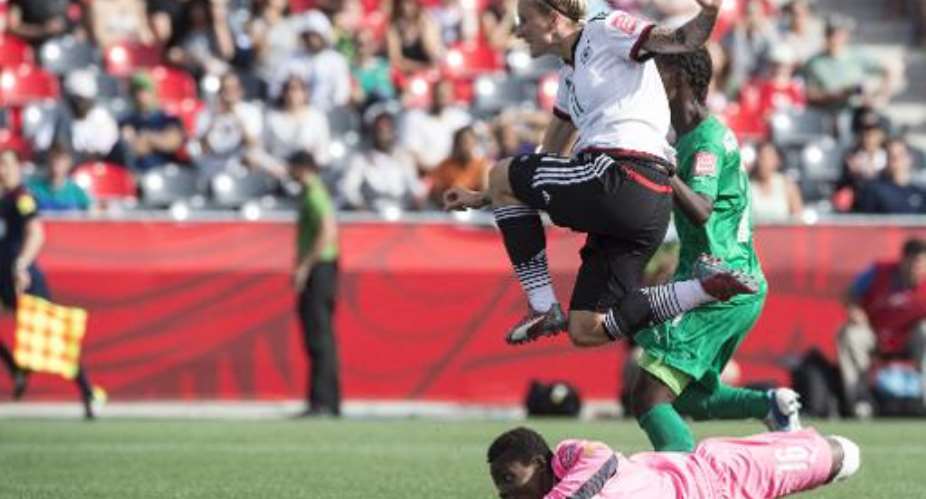 Germany's Anja Mittag jumps over Ivory Coast goalkeeper Dominique Thiamale as they watch the ball enter the goal during a Group B match at the 2015 FIFA Women's World Cup at Landsdowne Stadium in Ottawa on June 7, 2015.  By Nicholas Kamm AFP
