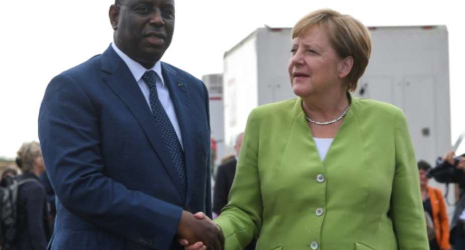 Germany's Chancellor Angela Merkel met by Senegal's President Macky Sall upon her arrival at Diass Airport on the outskirts of Dakar.  By SEYLLOU AFP