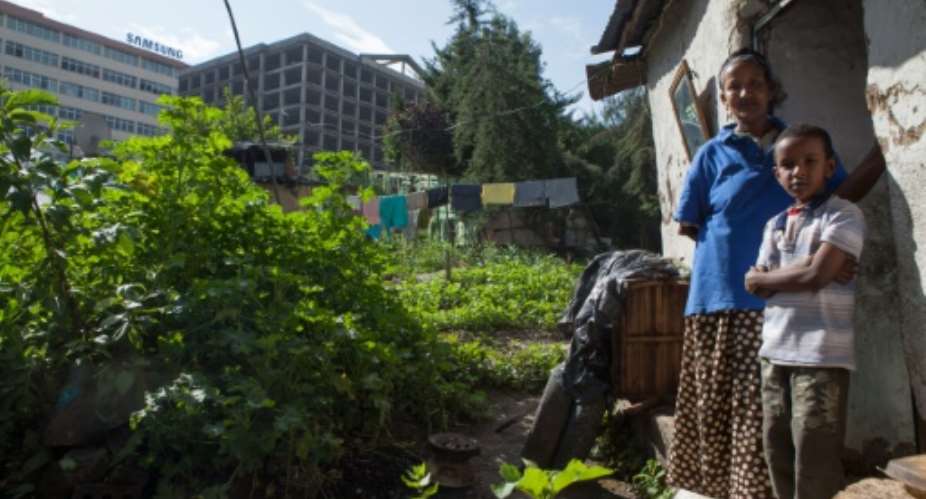 Getnesh Amare, 41, with her son near her home in the Kazanches neighborhood of Addis Ababa, Ethiopia, which has been singled out for redevelopment.  By Zacharias Abubeker (AFP/File)