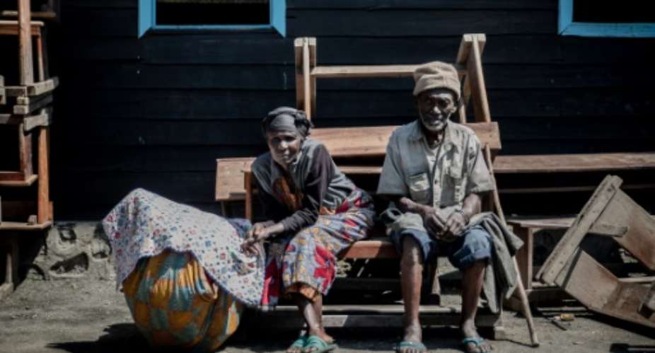 Going back: Two elderly people who fled Goma wait with their possessions for the ride home.  By GUERCHOM NDEBO AFP