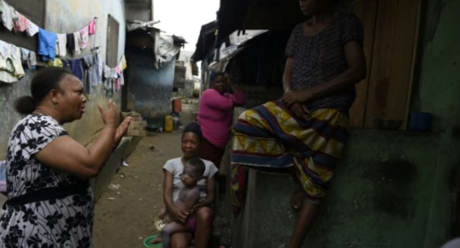 Grassroots message: MSF volunteer Christine Harrison, left, talks to a family about sexual abuse.  By PIUS UTOMI EKPEI AFP
