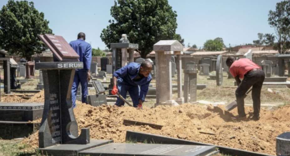 Gravediggers in Johannesburg, where between 45 and 60 graves are re-opened each week on average to allow for second burials.  By GIANLUIGI GUERCIA AFP