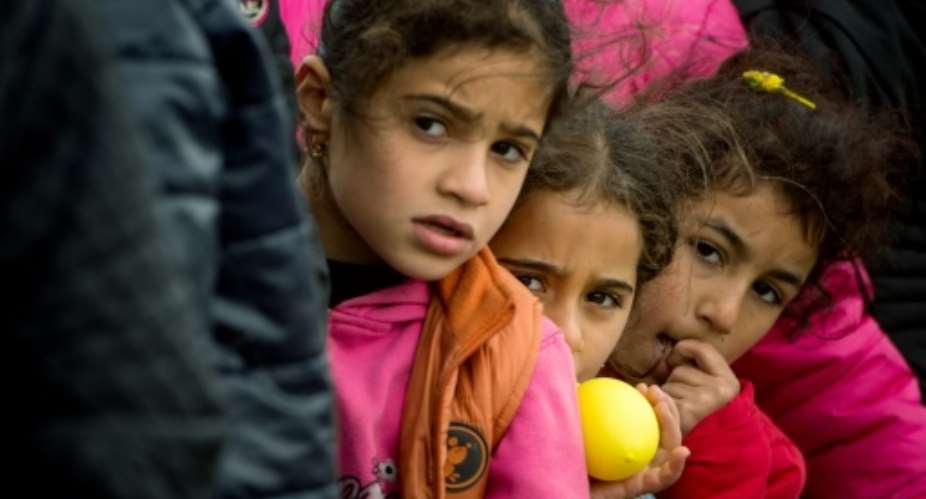 Children queue up for food at a makeshift camp for refugees and migrants at the Greek-Macedonian border near the village of Idomeni on March 24, 2016.  By Andrej Isakovic (AFP)