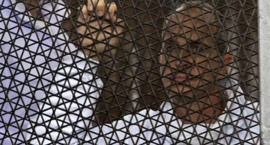 Australian journalist Peter Greste of Al-Jazeera standing inside the defendants cage during his trial at Cairo's Tora prison in Egypt, on March 5, 2014.  By Khaled Desouki AFPFile
