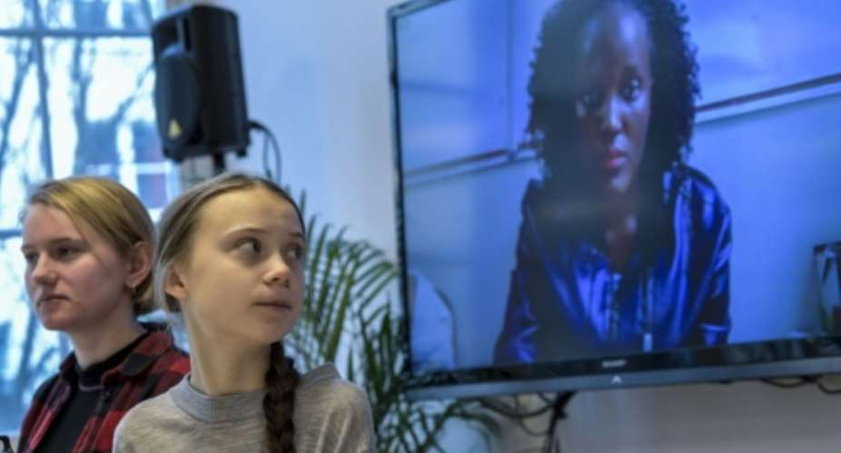 Greta Thunburg watches fellow eco warrior Vanessa Nakate, speaking from Kampala, after she was cropped out of a photo of young activists.  By Pontus LUNDAHL TT News AgencyAFP