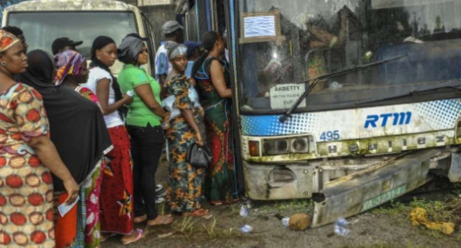 Voters queue during presidential elections at a polling booth inside a run-down bus in Conakry on October 11, 2015.  By Cellou Binani AFPFile
