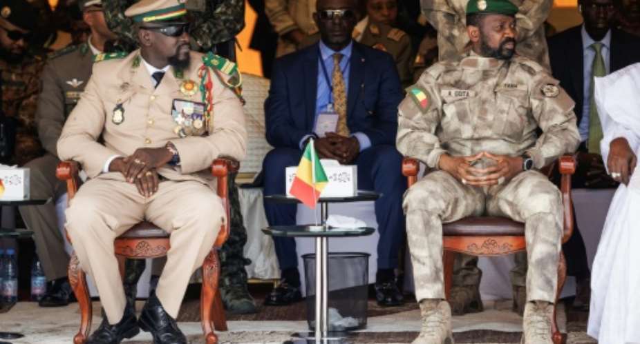 Guinea's head of the ruling junta, Mamady Doumbouya L, seen here alongside Mali's junta leader, Colonel Assimi Goita R, has promised to hand the reins of government back to elected civilians within two years.  By OUSMANE MAKAVELI AFP
