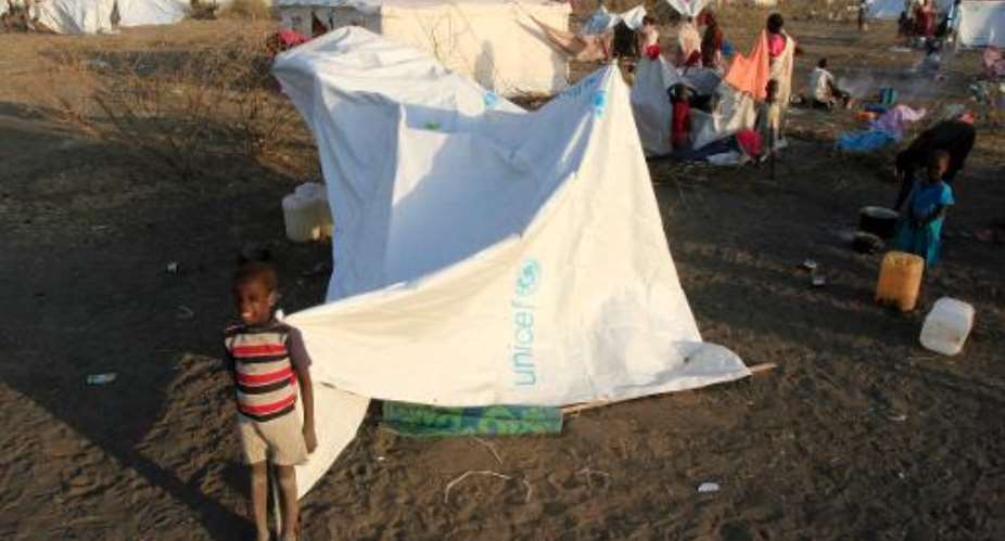 South Sudanese refugees stand near makeshift tents on January 26, 2014 in the western part of Sudan's White Nile state near South Kordofan.  By Ashraf Shazly AFPFile