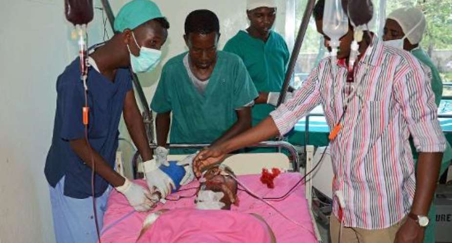 Medina Hospital medical staff treat Mohamed Mohamud Timacad, a reporter with London-based Somali-language Universal TV, who was shot several times in the neck and shoulder on October 22, 2013 in Mogadishu.  By Mohamed Abdiwahab AFP