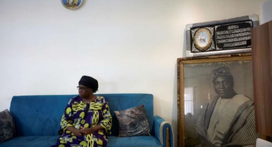 Hatouma Keita, Modibo Keita's daughter, poses next to a portrait of her father in Bamako.  By MICHELE CATTANI AFP
