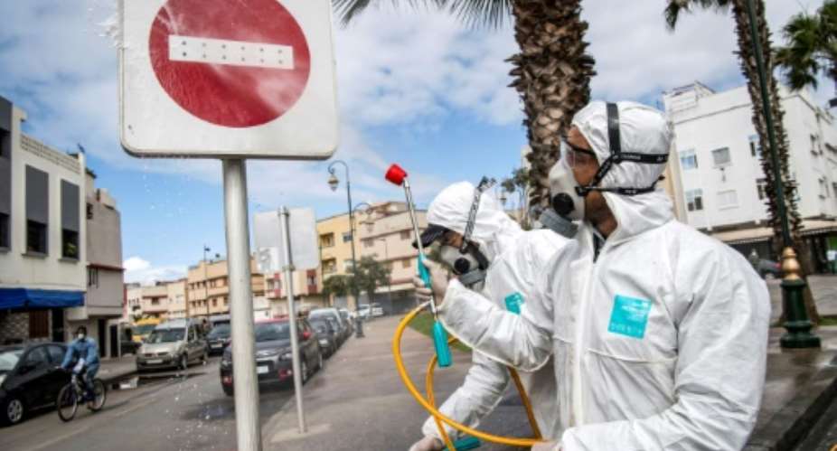 Health ministry workers pictured March 22, 2020 disinfect the streets of Rabat, the capital of Morocco, where the government has approved the use of hydroxychloroquine to treat the coronavirus.  By FADEL SENNA AFPFile