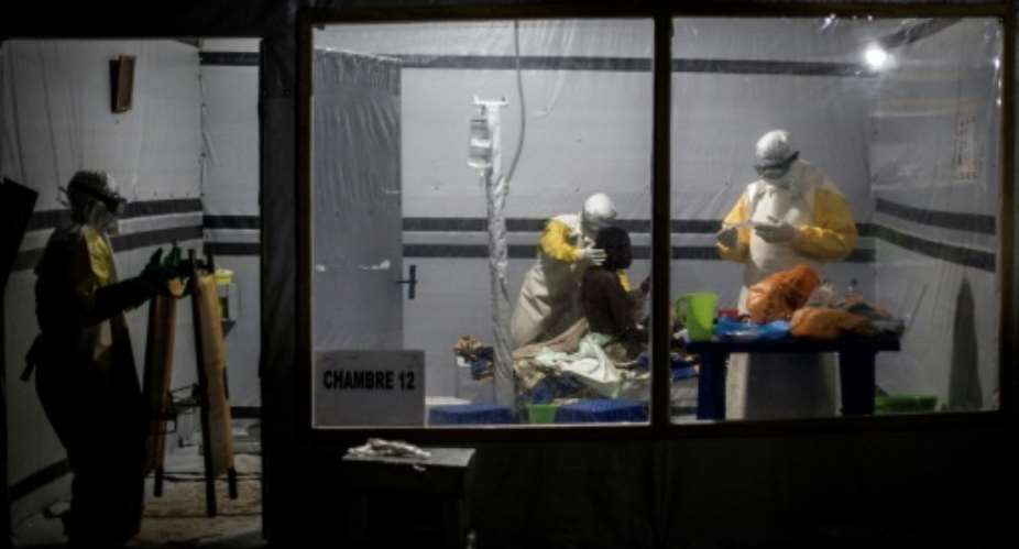 Health workers treat a possible Ebola patient inside a Doctors Without Borders-supported Ebola Treatment Center in east Democratic Republic of Congo, where the aid organization has partly suspended non-essential work after gunmen abducted two staff.  By John WESSELS AFPFile