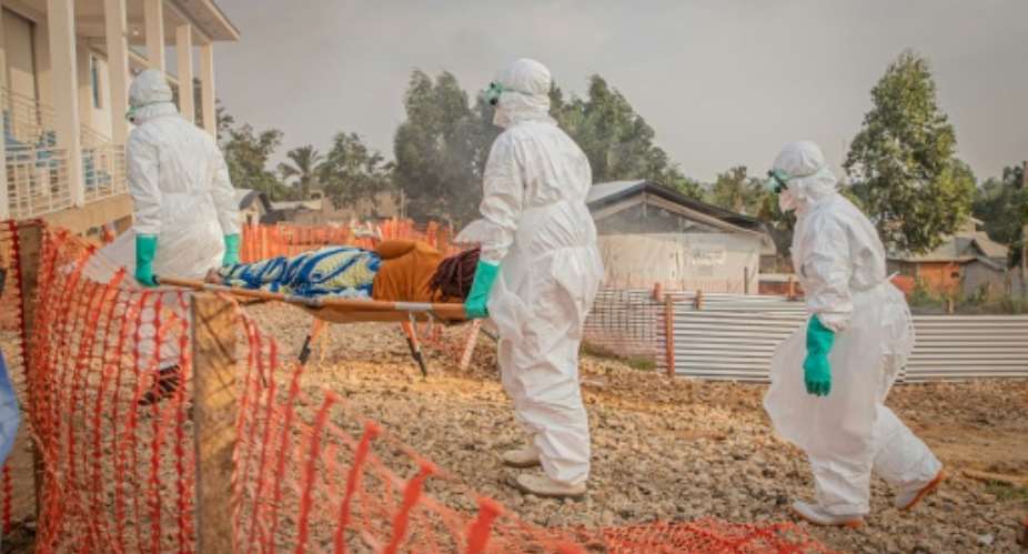 Healthcare workers carry on a stretcher a patient suffering from Ebola at a treatment centre in Bunia.  By Benediction MURHABAZI (AFP)