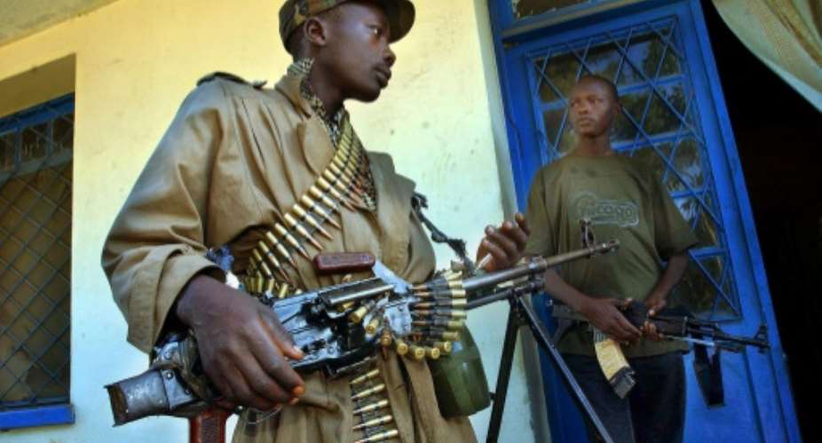 Heavily armed militiamen guard a party office in Bunia, the main city in the volatile Ituri province.  By MARCO LONGARI AFPFile