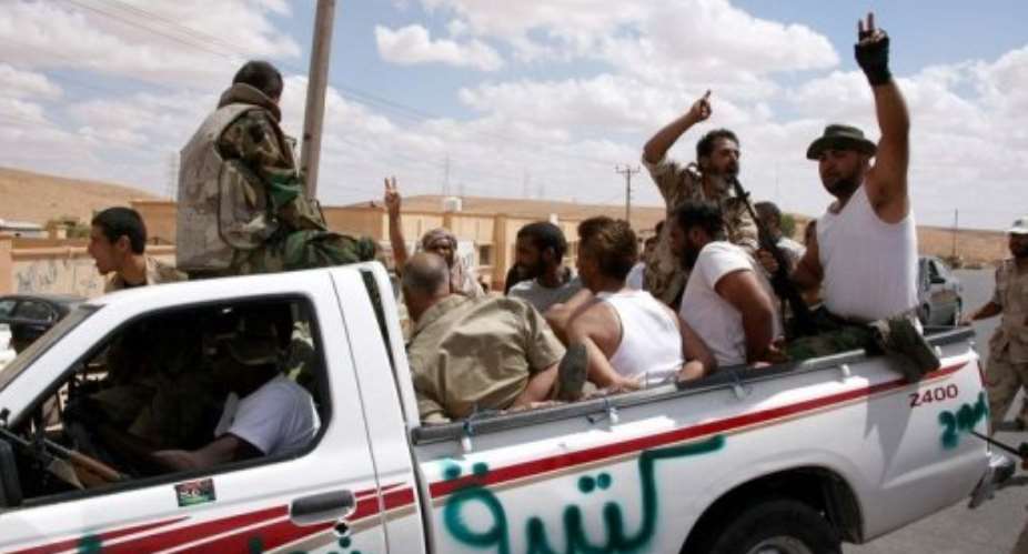 Fighters with the National Transitional Council escort detained loyalists at the back of a pick-up near Bani Walid.  By Mahmud Turkia (AFP)