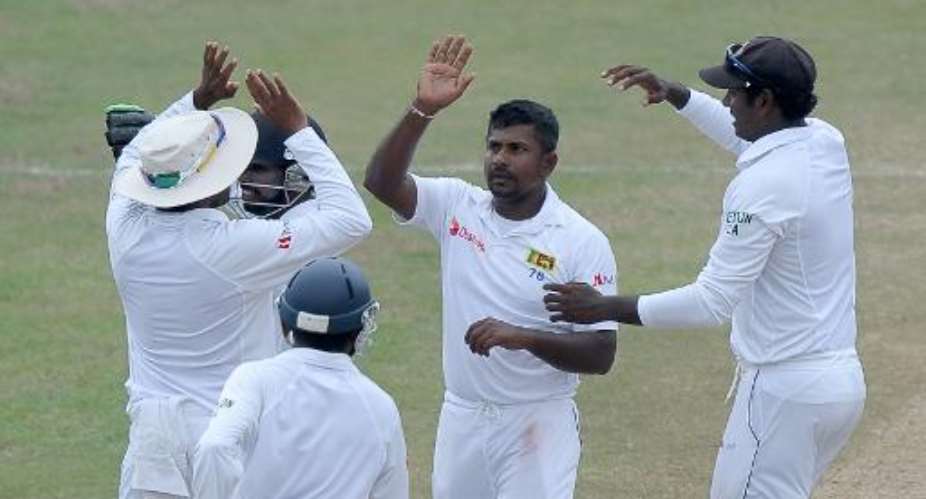 Sri Lankan bowler Rangana Herath 2nd right celebrates with teammates the dismissal of South African batsman Quinton de Kock during the fifth and final day of their second Test match in Colombo on July 28, 2014.  By Lakruwan Wanniarachchi AFP