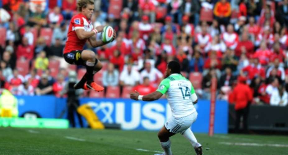 Lions' Andries Coetzee jumps with the ball past Highlanders' Waisake Naholo at Ellis Park on July 30, 2016 in Johannesburg, South Africa.  By  AFP
