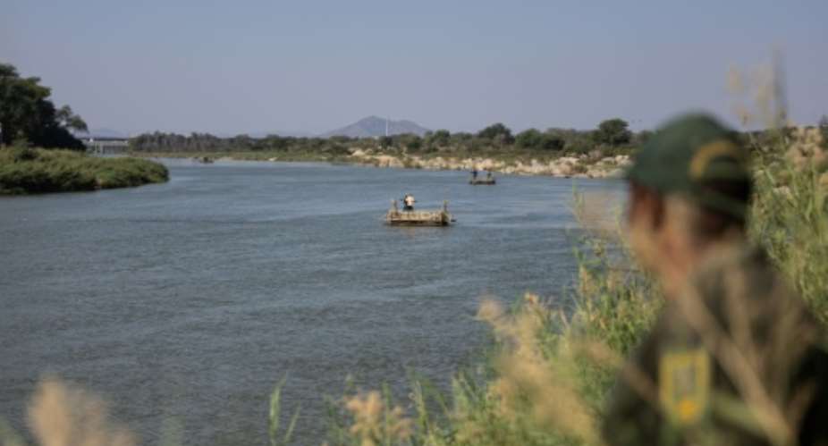 Hundreds of people cross into South Africa through the Limpopo River.  By EMMANUEL CROSET (AFP)