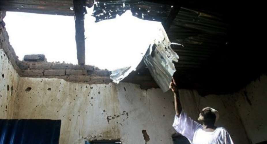 A Sudanese man points to damages at his house caused by fighting that erupted in June in Kadugli, South Kordofan.  By Ashraf Shazly (AFP/File)