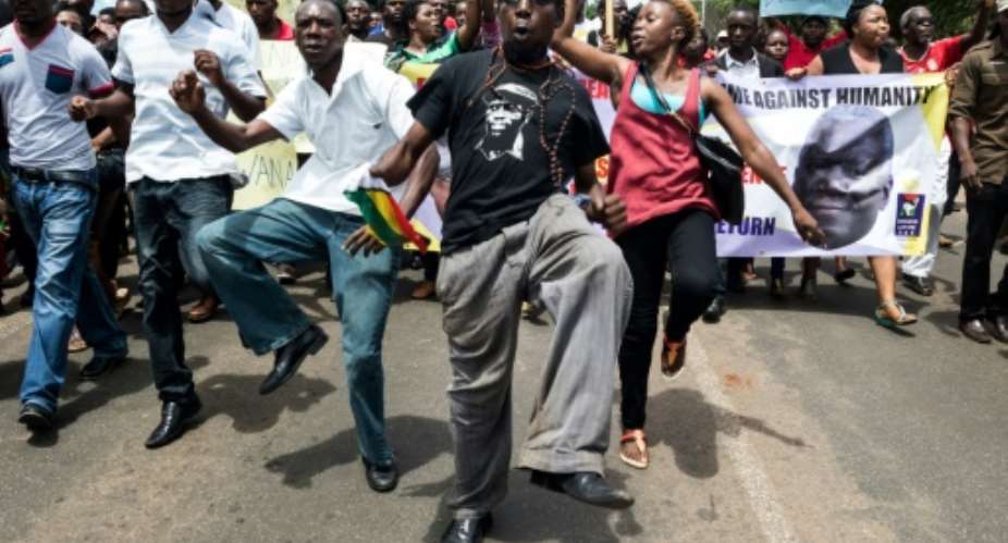 Demonstrators sing, dance and shout political slogans during a march to mark the one year anniversary of the disappearance of Itai Dzamara in Harare  on March 9, 2016.  By Jekesai Njikizana AFP