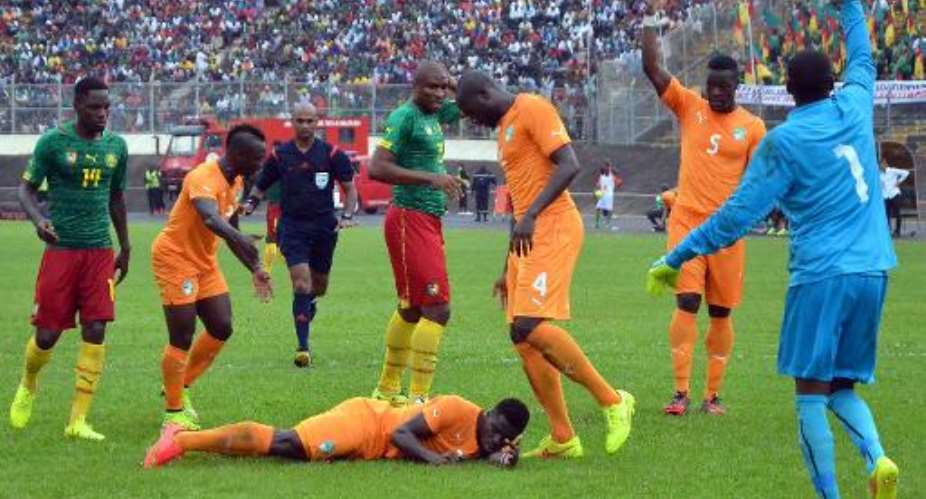 Cameroon and Ivory Coast players gather around Ivory Coast defender Serge Aurier C after he was injured in a clash of heads during the 2015 African Cup of Nations qualifier in Yaounde on September 10, 2014.  By  AFP