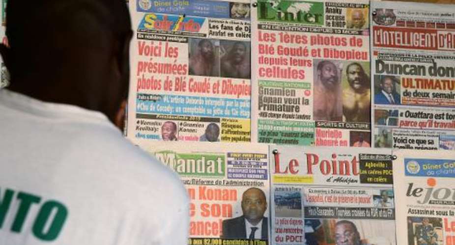 A man looks at the front pages of newspapers claiming to show pictures of Charles Ble Goude, the former right-hand man of Ivorian ex-president Laurent Gbagbo, March 10, 2014 in Abidjan.  By Issouf Sanogo AFPFile