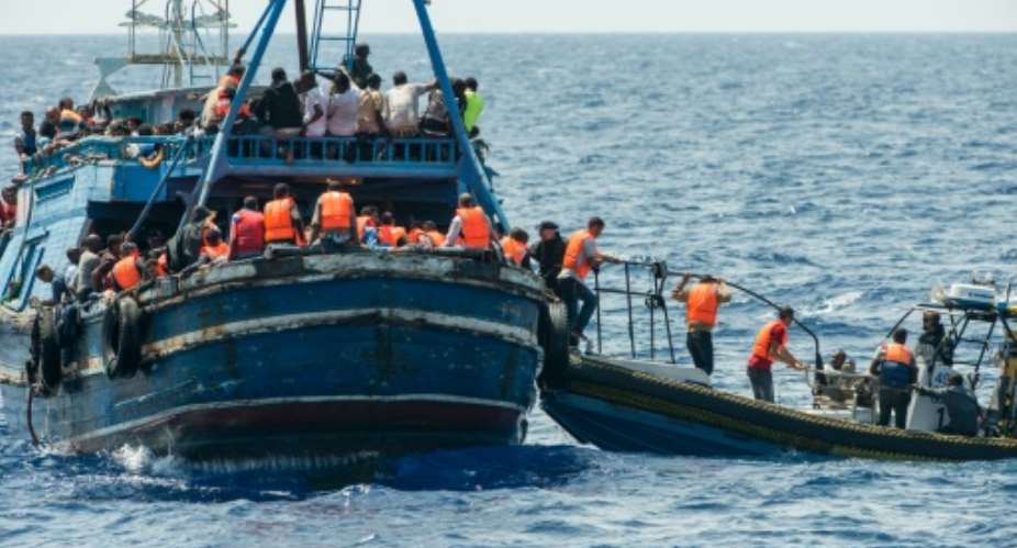 This handout picture released by MSF on August 27, 2015 shows migrants on a wooden boat during a rescue operation by MSF and the Swedish coast guard in the Meditterranean sea on August 26, 2015.  By Gabriele Francois Casini Medecins Sans FrontieresAFP