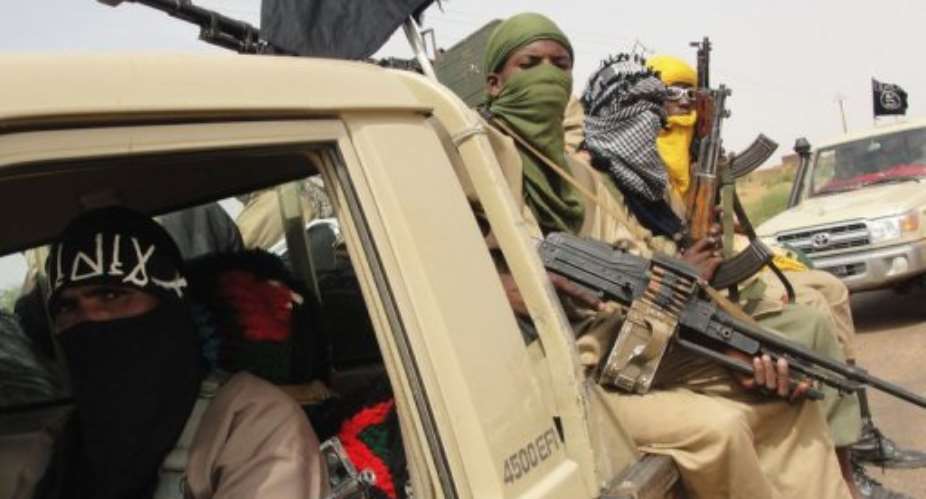 Fighters of the Islamic group Ansar Dine stand guard at the Kidal Airport in northern Mali.  By Romaric Hien (AFP/File)