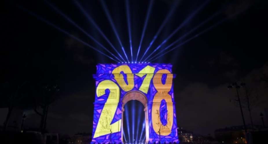 Images are projected on the Arc de Triomphe monument during the New Year celebration in Paris.  By GUILLAUME SOUVANT AFP