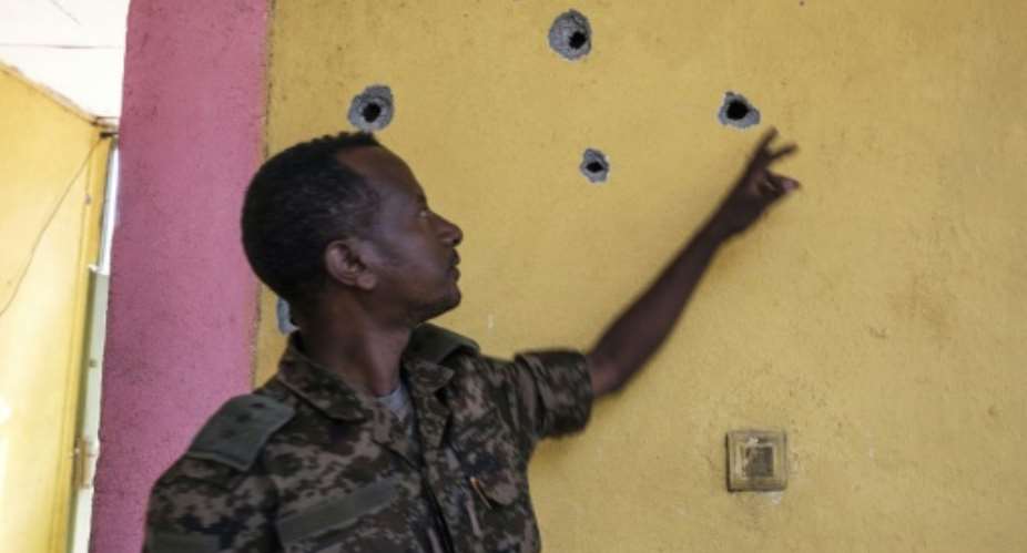 Impact: An Ethiopian soldier points to bullet holes left after the attack on the base in Dansha.  By EDUARDO SOTERAS AFP