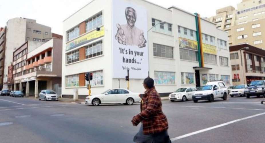 A huge banner of former President Nelson Mandela hangs over the Hindu Tamil Instituite in Durban on July 17, 2013.  By Rajesh Jantilal AFP