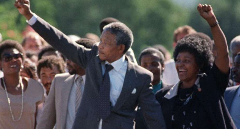 In 1990, Winnie Mandela famously joined hands with her husband Nelson as he walked out of prison. But her key role in sustaining the early anti-apartheid struggle was stained later by a reputation for coercion and violence.  By ALEXANDER JOE (FILES/AFP/File)