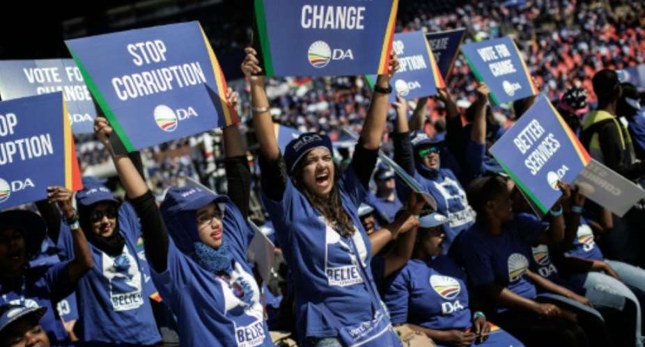 South Africa main opposition party Democratic Alliance supporters hold signs as they attend a campaign rally on April 23, 2016 at the Rand Stadium in Johannesburg.  By Gianluigi Guercia AFPFile