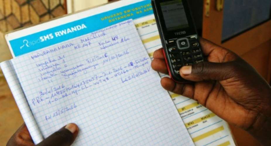 A pregnant woman records her information by SMS on the country's RapidSMS health system on April 27, 2016 in Nyarukombe, Rwanda.  By Stephanie Aglietti AFPFile