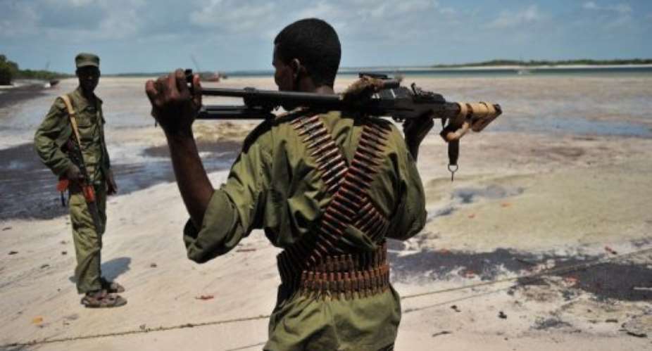 Militia allied with the federal government of Somalia walk along the coast near Burgabo village.  By Carl de Souza (AFP/File)