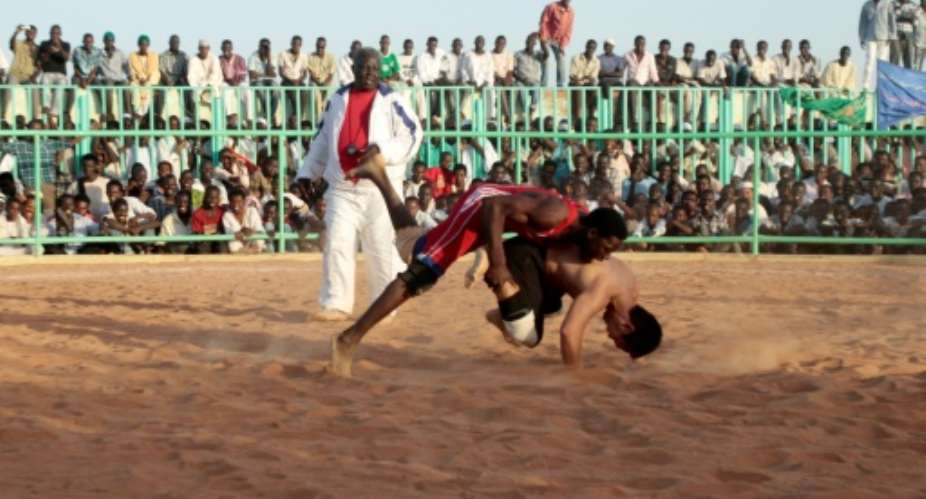 In this file photo from 2013, Japanese diplomat Yasuhiro Murotatsu, aka Muro R competes against Saleh Omar Bol Tia Kafi aka al-Mudiriya in a Nuba wrestling match in Khartoum.  By ASHRAF SHAZLY AFPFile
