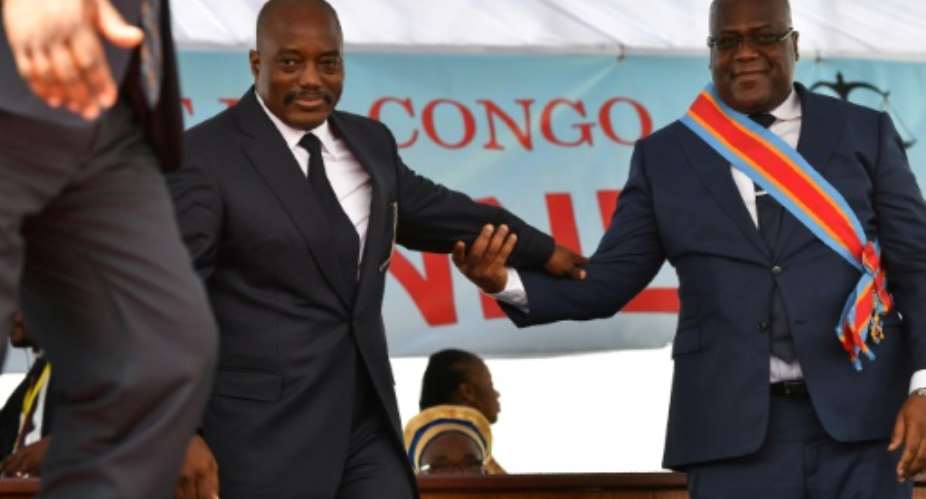 Inauguration day: Outgoing president Joseph Kabila and successor Felix Tshisekedi mark DR Congo's first-ever peaceful transition of power. Kabila still overshadows the national political scene, wielding clout acquired during 18 years in office.  By TONY KARUMBA AFP